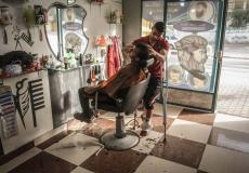 معاذ يمارس مهنة الحلاقة رغم إصابته