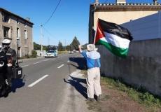 ناشط يرفع علم فلسطين خلال مشاركة فريق إسرائيلي في مسابقة سباق فرنسا للدراجات