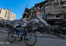 فلسطيني يمر بالقرب من قصف اسرائيلي استهدف أحد الأبراج في غزة