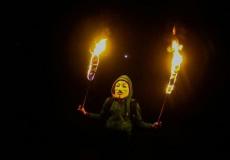 شباب من غزة يحمل شعلة نار خلال الارباك الليلي على حدود القطاع