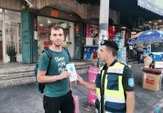 الشرطة توزع نشرات التوعية من فيروس كورونا على  المواطنين