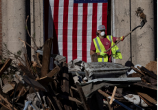 أحد المتطوعين يعمل على ازالة الركام من أحد المنازل التي تعرضت للاعصار في ولاية كنتاكي