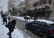 أطفال يعلبون بالثلوج في مدينة الخليل