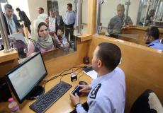 شرطي يتفقد جواز سفر فلسطينية في معبر رفح البري