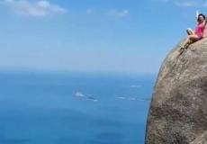 مشهد يحبس الأنفاس لامرأة تجلس على قمة جبل في البرازيل