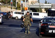 جندي اسرائيلي يتفقد مكان تفجير محطة الحافلات المركزية بالقدس