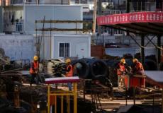 عمال يعملون في موقع بناء بعد تفشي فيروس كورونا في الصين