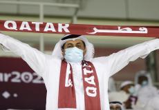 مشجع في كأس العالم يحمل شارة كتب عليها قطر