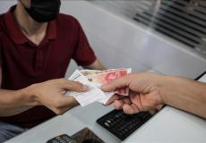 فلسطيني يتلقى أموالا ضمن المنحة القطرية في غزة
