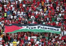 الجماهير ترفع علم فلسطين خلال مباراة تونس وأستراليا بكأس العالم في قطر (رويترز)