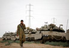 جندي في الجيش الإسرائيلي بجوار الآليات العسكرية