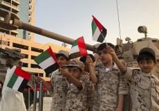 أطفال يلوحون بعلم الإمارات بكل فخر