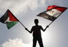 طفل يرفع علمي مصر وفلسطين - تعبيرية