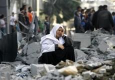 أم فلسطينية تجلس على حطام منزلها المدمر في غزة - تعبيرية