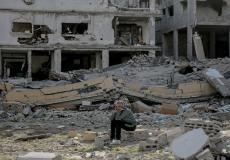 مسن فلسطيني يجلس على أنقاض الدمار