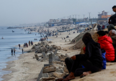 مواطنون من غزة يجلسون على ساحل بحر غزة لاستقبال المساعدات - تعبيرية