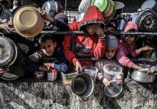 أطفال ينتظرون الطعام الذي يتم توزيعه بشكل مجاني