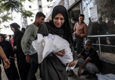 سيدة تحمل جثمان طفلها الرضيع الذي استشهد بغارة إسرائيلية على مدينة غزة، الشهر الماضي ( Getty Images)