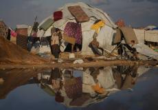 امرأة وطفل أمام خيمتهما في مخيم للنازحين على شاطئ مدينة غزة الثلاثاء (أ.ب)