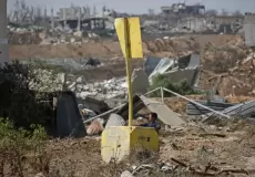 فتى فلسطيني قرب علامة "الخط الأصفر" شرقي دير البلح بقطاع غزة يوم 22 يوليو/تموز 2026 (الفرنسية)