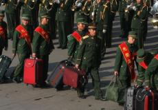 جنود صينيون يحملون أمتعتهم بعد تسريحهم من الجيش