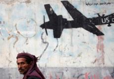 مواطن يمني يعبر جانب جدار برسومات غرافيتية لدرون