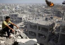 فتى فلسطيني يجلس على انقاض منزله بغزة