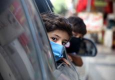 طفل يرتدى كمامة تخوفا من فيروس كورونا في غزة- APA