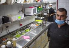 عمال يجهزون وجبات طعام في مطعم في تل أبيب أمس 