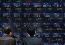 متعاملان يتابعان حركة الأسهم في بورصة طوكيو 