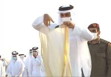 أمير قطر وهو يقلب ردائه