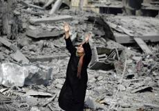 امرأة فوق أنقاض منزلها المدمر بغزة- أرشيفية