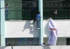 طفل يتسلق جدار أحد المدارس بغزة