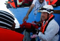 أحد المنقذين يحمل طفلا