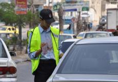 شرطي بغزة يفحص أوراق أحد السيارات