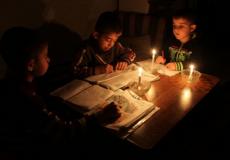 أطفال يدرسون على الشموع