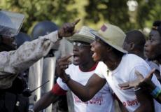 أنصار المعارضة في عاصمة هايتين بورتو برنس يجادلون أحد عناصر الشرطة