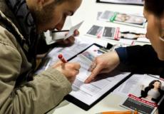 لاجئ يعبئ طلبا للعمل في معرض للوظائف في برلين - فبراير 2016.