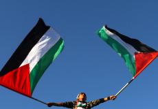 فتى فلسطيني يحمل رايات فلسطين دعما للمصالحة