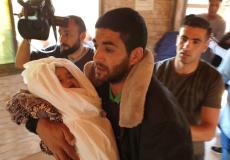 والد الطفلة صبا ابو عرار يحتضنها