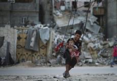 طفل يلهو مع أخيه بغزة