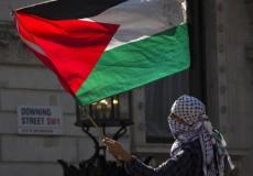 شاب فلسطيني يلوح بالعلم الفلسطيني في إحدى الدول الأوروبية