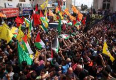 متظاهرون يرفعون أعلام فصائل فلسطينية