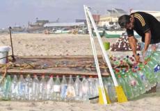 الشاب معاذ أبو زيد يجهز قارب الصيد من العبوات البلاستيكية