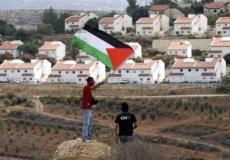 شاب يرفع علم فلسطين في مستوطنة بالضفة - توضيحية