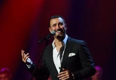 فتاة تعانق كاظم الساهر أثناء غنائية على المسرح 