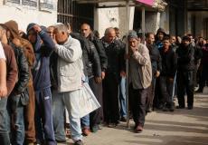 مواطنون مستفيدون من شيكات الشؤون الاجتماعية يصطفون أمام بنك فلسطين