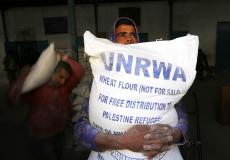 لاجئ فلسطيني يتسلم معونة غذائية من الأونروا في غزة