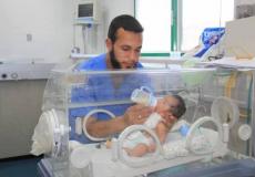 ممرض يقدم الحليب لطفل في احد المستشفيات بقطاع غزة