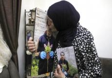 والدة الشهيد إياد الحلاق تقببل صورته 